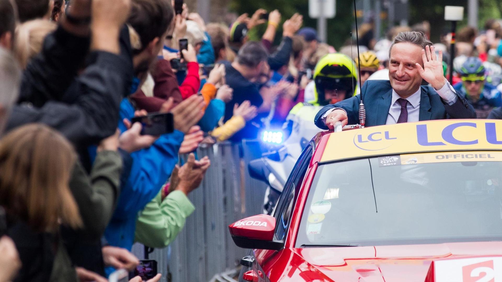Oberbürgermeister Thomas Geisel winkt aus dem Führungsauto bei der 2. Etappe Oberbürgermeister Thomas Geisel winkt aus dem Führungsauto bei der 2. Etappe