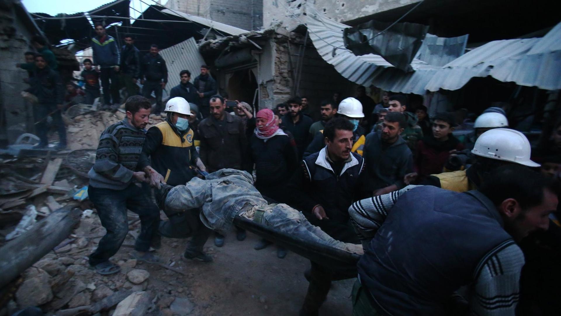 Mitglieder des syrischen Zivilschutzes "White Helmets" evakuieren ein Opfer der Kämpfe in Ost-Ghouta in Syrien