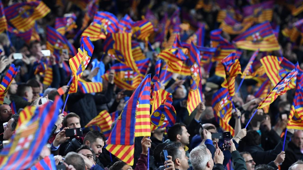 Die Fans des FC Barcelona schwenken Vereinsfahnen im Stadion Camp Nou. Die Fans des FC Barcelona schwenken Vereinsfahnen im Stadion Camp Nou.