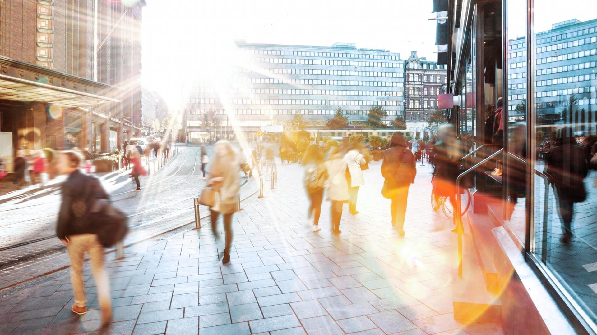Menschen hasten zwischen hohen Bürogebäuden in der untergehenden Snne zum nächsten Ziel. Menschen hasten zwischen hohen Bürogebäuden in der untergehenden Snne zum nächsten Ziel.