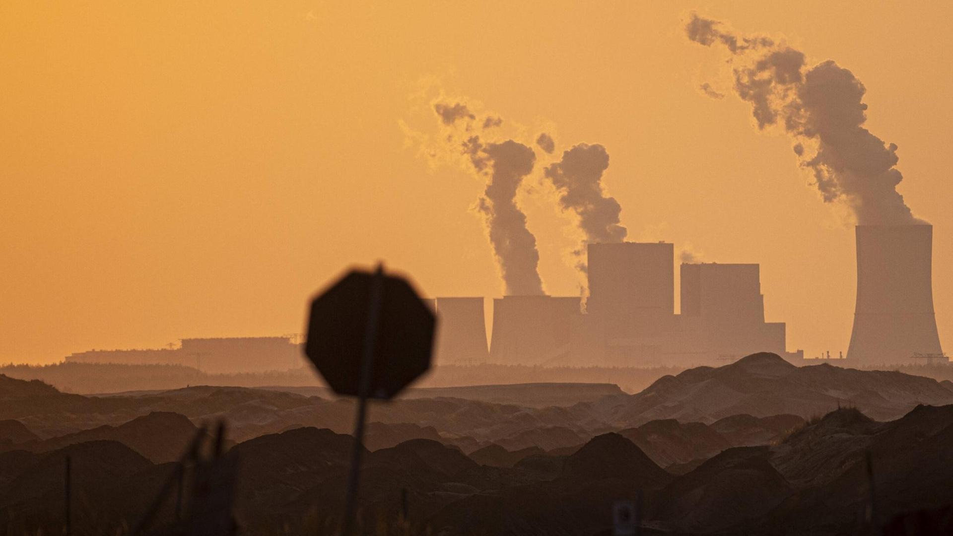 Ein Stoppschild zeichnet sich in der Abenddämmerung vor dem Kohlekraftwerk Boxberg ab. Ein Stoppschild zeichnet sich in der Abenddämmerung vor dem Kohlekraftwerk Boxberg ab.