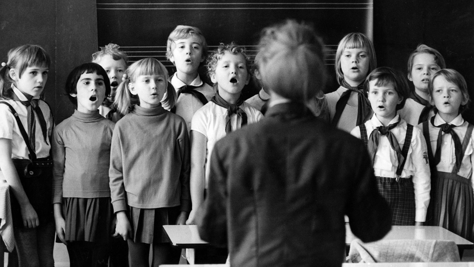 Schulalltg in Dresden, 1970: Pioniere und Lehrerin singen ein Lied zum Start in den Unterrichtstag. Schulalltg in Dresden, 1970: Pioniere und Lehrerin singen ein Lied zum Start in den Unterrichtstag.
