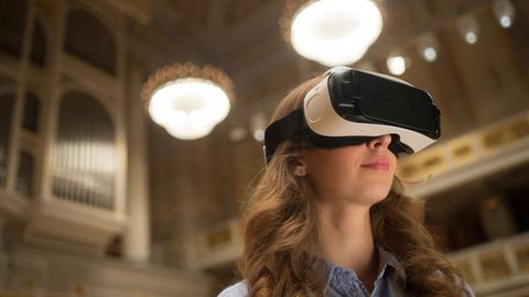 Eine junge Frau trägt die Virtual-Reality-Brille, die das Konzerthaus Berlin mit der Hochschule für Technik und Wirtschaft entwickelt hat.