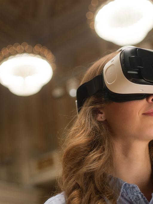 Eine junge Frau trägt die Virtual-Reality-Brille, die das Konzerthaus Berlin mit der Hochschule für Technik und Wirtschaft entwickelt hat.