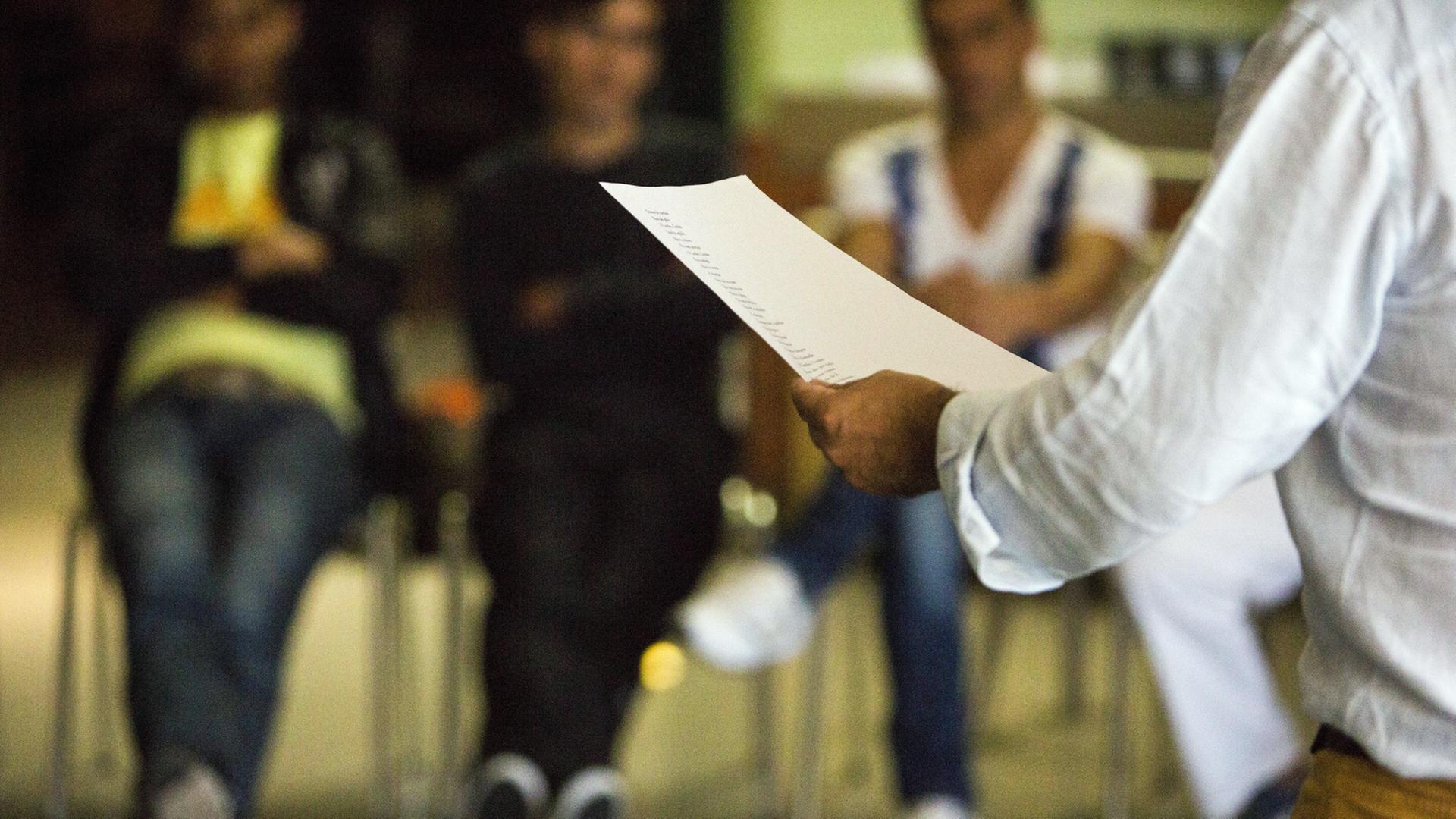 Poetry-Session von Filipe Lopes mit Gefangenen im Gefängnis Santa Cruz. Man sieht ihn von hinten vor Zuhörern, in der Hand einen Zettel mit einem Gedicht. Poetry-Session von Filipe Lopes mit Gefangenen im Gefängnis Santa Cruz. Man sieht ihn von hinten vor Zuhörern, in der Hand einen Zettel mit einem Gedicht.
