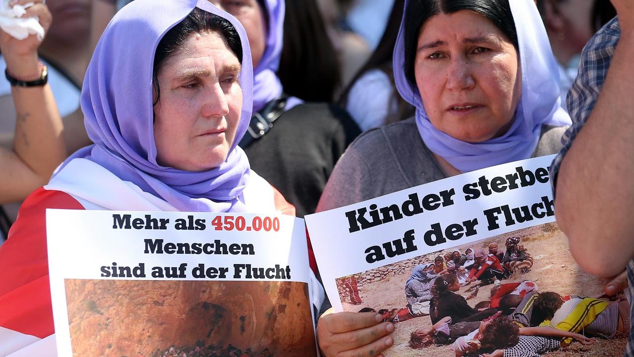 Demonstranten protestieren am 03.08.2015 unter dem Fernsehturm in Berlin gegen die Verfolgung der Jesiden durch den islamischen Staat im Nordirak.