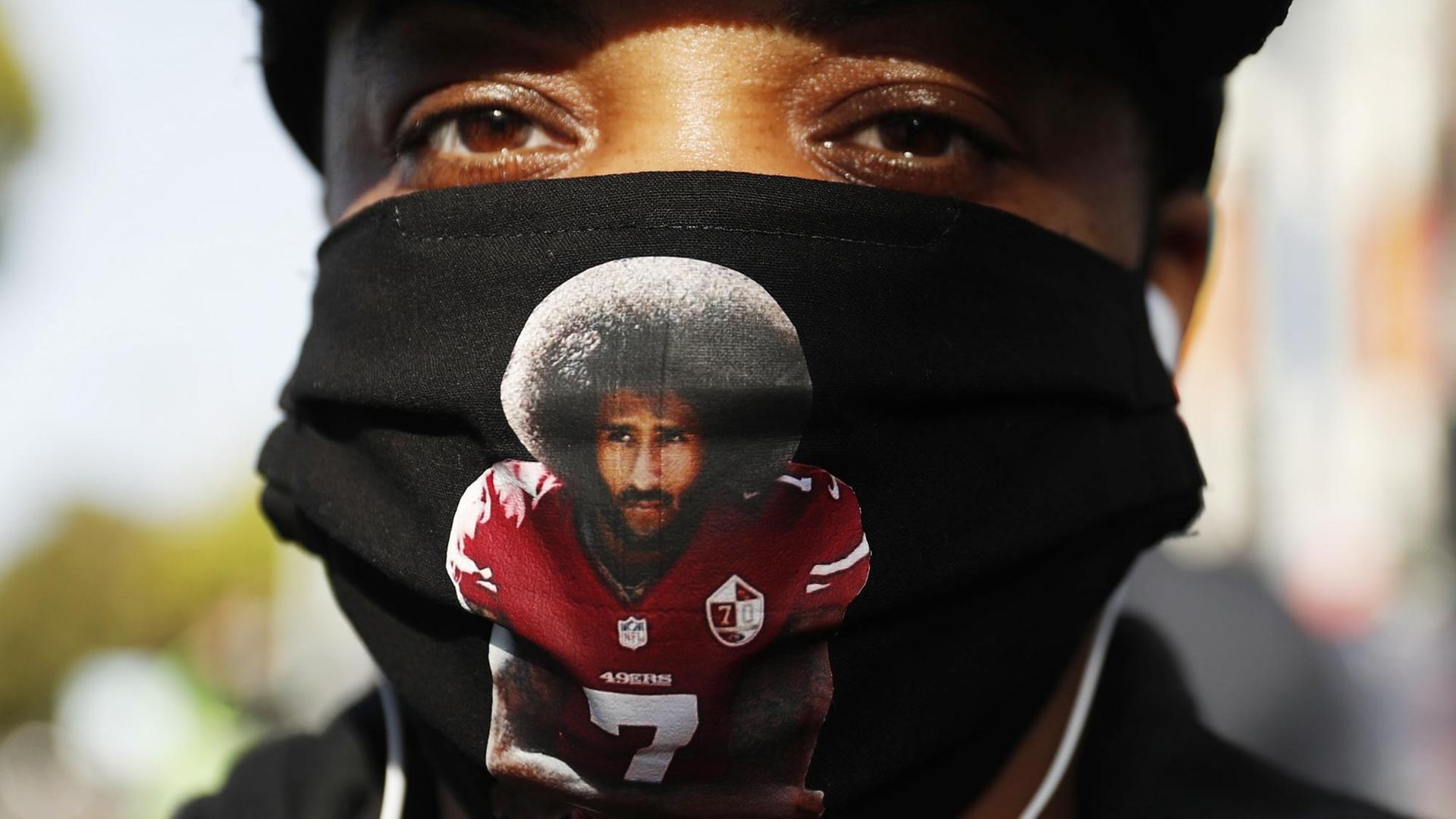 Eine Demonstrantin bei Black Lives Matter Protesten trägt Colin Kaepernick auf einer schwarzen Gesichtsmaske, San Francisco, 15. Juni 2020. Eine Demonstrantin bei Black Lives Matter Protesten trägt Colin Kaepernick auf einer schwarzen Gesichtsmaske, San Francisco, 15. Juni 2020.