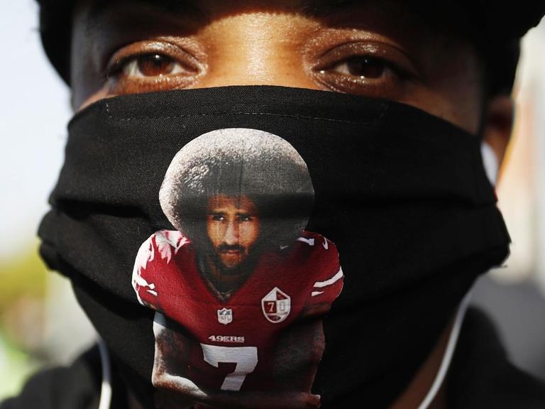 Eine Demonstrantin bei Black Lives Matter Protesten trägt Colin Kaepernick auf einer schwarzen Gesichtsmaske, San Francisco, 15. Juni 2020.