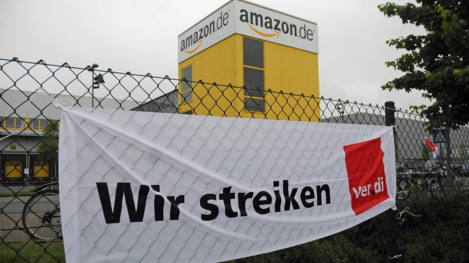 Am Zaun vor dem Amazon-Lager in Leipzighängt ein Verdi-Plakat mit der Aufschrift "Wir streiken" Am Zaun vor dem Amazon-Lager in Leipzighängt ein Verdi-Plakat mit der Aufschrift "Wir streiken"