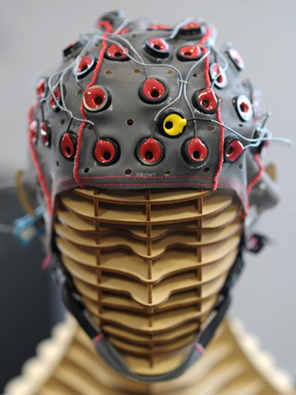 Eine Elektrodenhaube sitzt zur Vorführung eines Brain-Computer-Interface (BCI) in Würzburg (Unterfranken) auf einem hölzernen Kopfmodell.