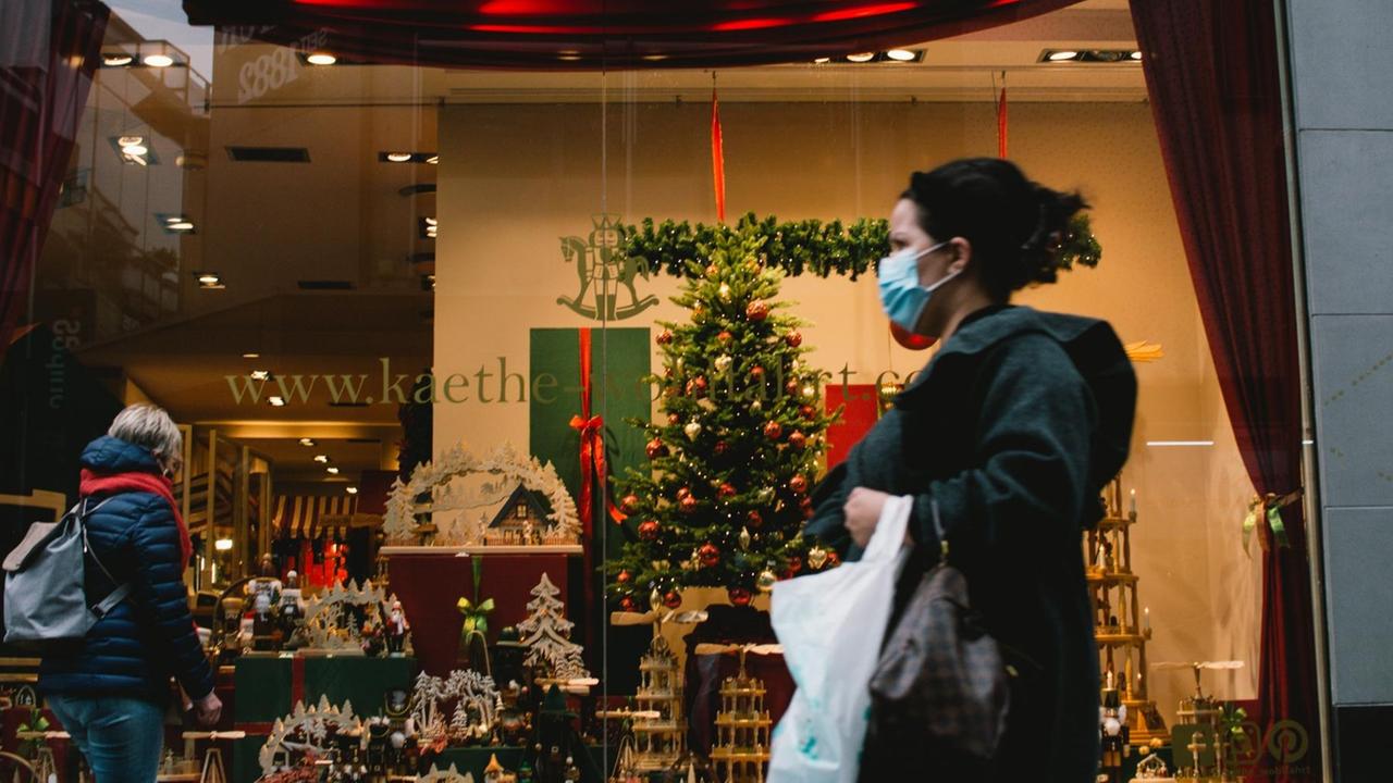 Eine Frau mit Mund-Nasen-Maske läuft ini Köln an einem Laden mit Weihnachtsdekoration vorbei. (Photo by Ying Tang/NurPhoto) | Keine Weitergabe an Wiederverkäufer. Eine Frau mit Mund-Nasen-Maske läuft ini Köln an einem Laden mit Weihnachtsdekoration vorbei. (Photo by Ying Tang/NurPhoto) | Keine Weitergabe an Wiederverkäufer.