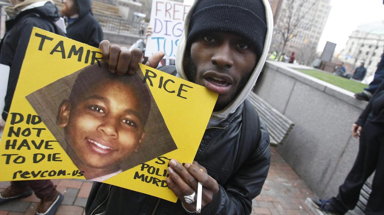 Demonstrant mit Plakat, welches ein Bild von Tamir Rice zeigt, der 2014 mit zwölf Jahren von einem Polizisten in Clevland, Ohio erschossen wurde.