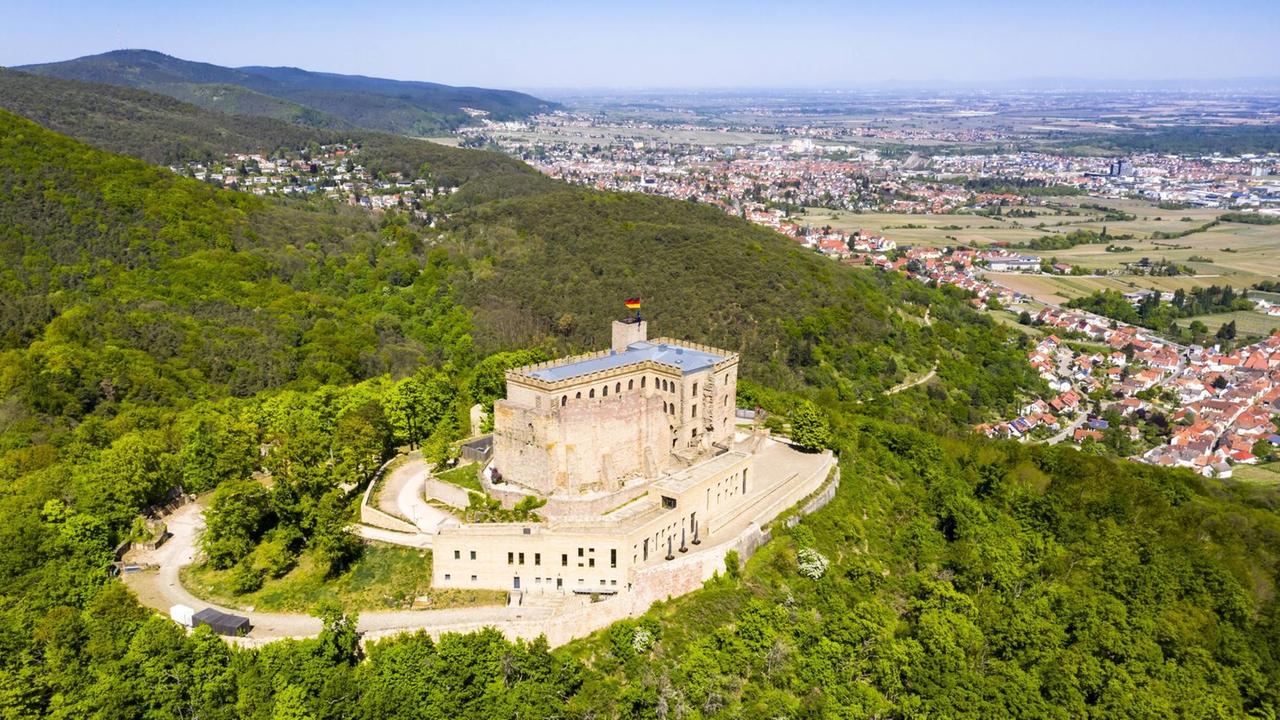 Helikopterblick auf die teilerhaltene Burg- bzw. Schlossanlage auf einem bewaldeten Berg mit Blick auf die nahe Gemeinde. Helikopterblick auf die teilerhaltene Burg- bzw. Schlossanlage auf einem bewaldeten Berg mit Blick auf die nahe Gemeinde.