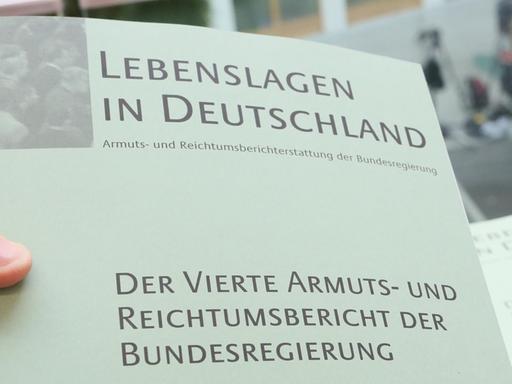 Ein Farbfoto zeigt eine Broschüre mit dem Schriftzug "Der vierte Armuts- und Reichtumsbericht der Bundesregierung" "Der vierte Armuts- und Reichtumsbericht der Bundesregierung" ist am 06.03.2013 in Berlin zu sehen. Foto: Stephanie Pilick/dpa Der Bericht Lebenslagen in Deutschland – Armuts- und Reichtumsbericht der Bundesregierung hier die vierte Ausgabe, erschienen 2013
