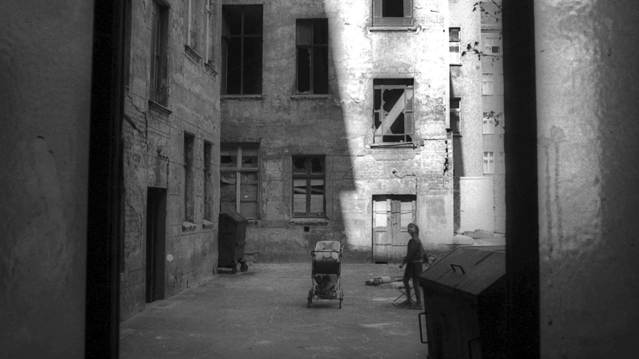 Ein Kinderwagen und ein Kind stehen in einem Hinterhof im Ost-Berliner Stadtbezirk Prenzlauer Berg, aufgenommen im Jahr 1981. Ein Kinderwagen und ein Kind stehen in einem Hinterhof im Ost-Berliner Stadtbezirk Prenzlauer Berg, aufgenommen im Jahr 1981.