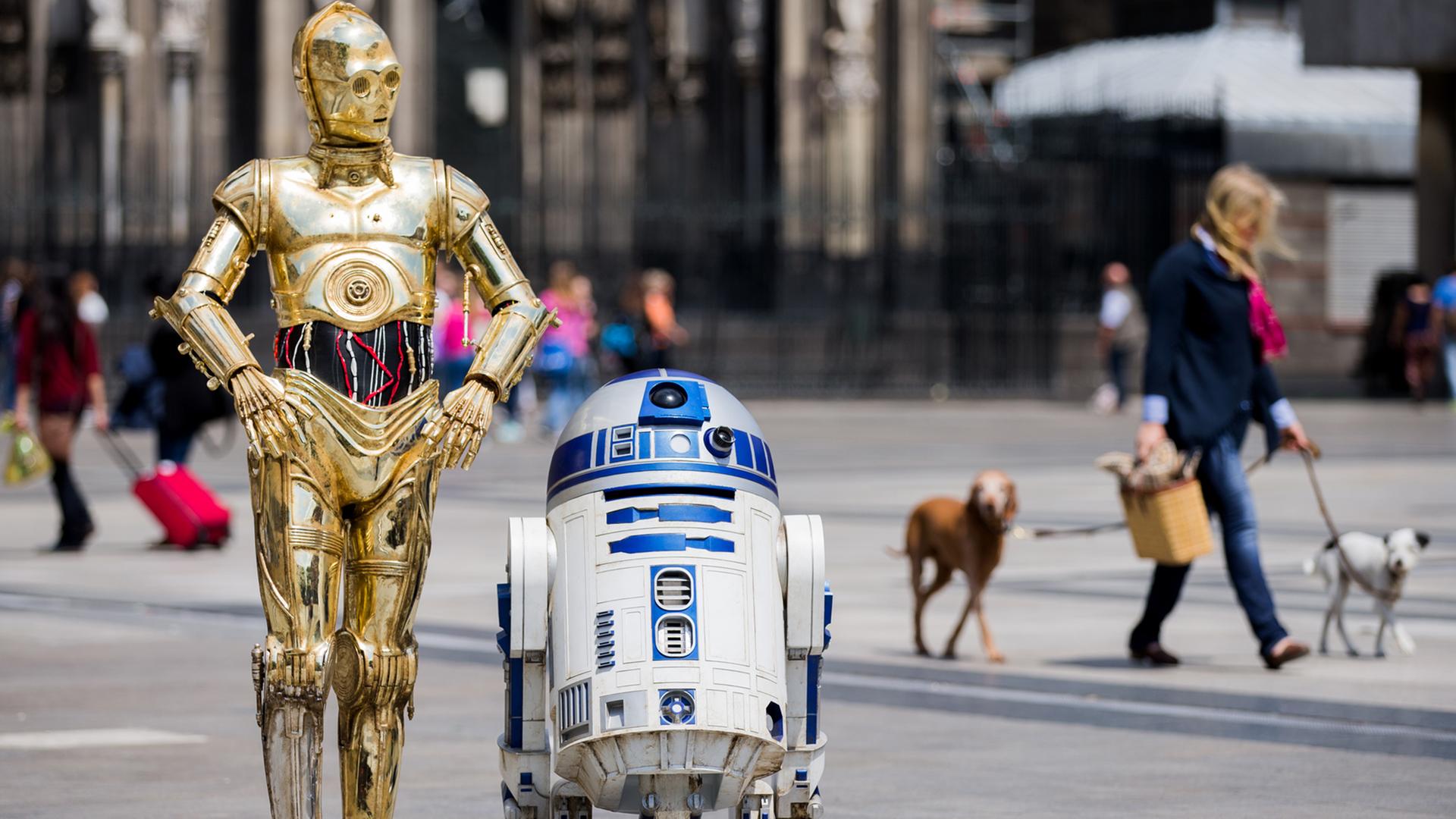 Die Roboter "C-3PO" (l) und R2-D2 aus den Star-Wars-Filmen als Wachsfiguren vor dem Kölner Dom. Die Roboter "C-3PO" (l) und R2-D2 aus den Star-Wars-Filmen als Wachsfiguren vor dem Kölner Dom.