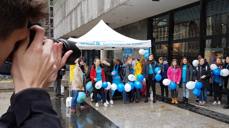 Diverse Kinder vor einem Gebäude, sie tragen blau-weiße Luftballons und werden von Pressefotografen abgelichtet. Diverse Kinder vor einem Gebäude, sie tragen blau-weiße Luftballons und werden von Pressefotografen abgelichtet.