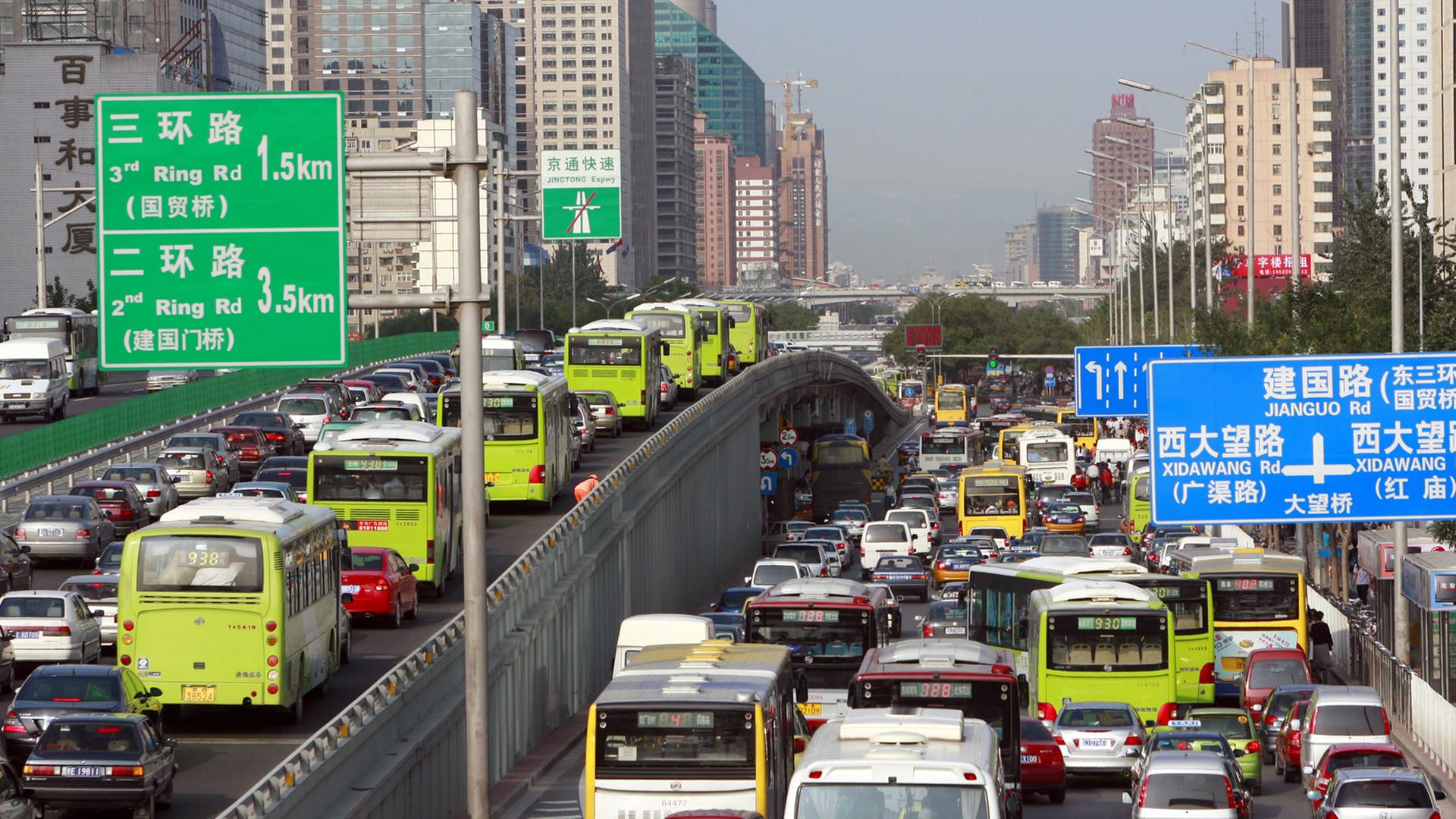 Rushhour in Peking. Eine Verkehrslawine wälzt sich durch die Straßen der Stadt, vorbei an Hochhäusern. Rushhour in Peking. Eine Verkehrslawine wälzt sich durch die Straßen der Stadt, vorbei an Hochhäusern.