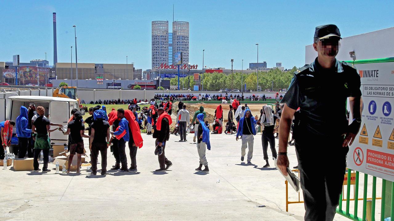 Migranten aus Afrika stehen am Hafen von Algeciras für Lebensmittel und Wasser an. Migranten aus Afrika stehen am Hafen von Algeciras für Lebensmittel und Wasser an.