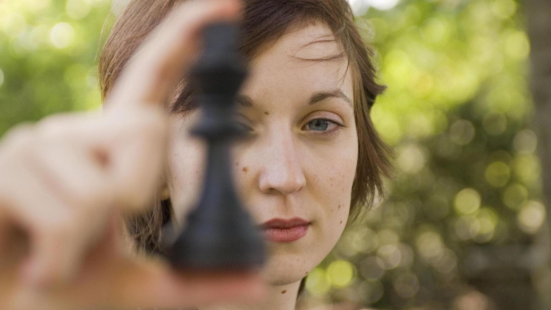 Elisabeth Pähtz hät eine schwarze Schachfigur in die Kamera.
