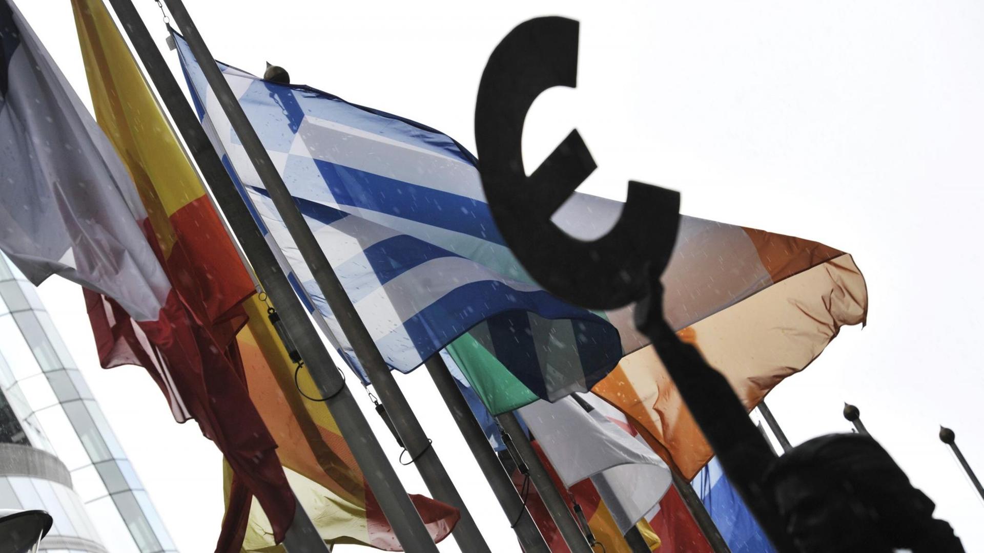 Flaggen vor dem EU-Parlament in Brüssel, davor eine Frauen-Statue, die das Eurozeichen in der Hand hält Flaggen vor dem EU-Parlament in Brüssel, davor eine Frauen-Statue, die das Eurozeichen in der Hand hält