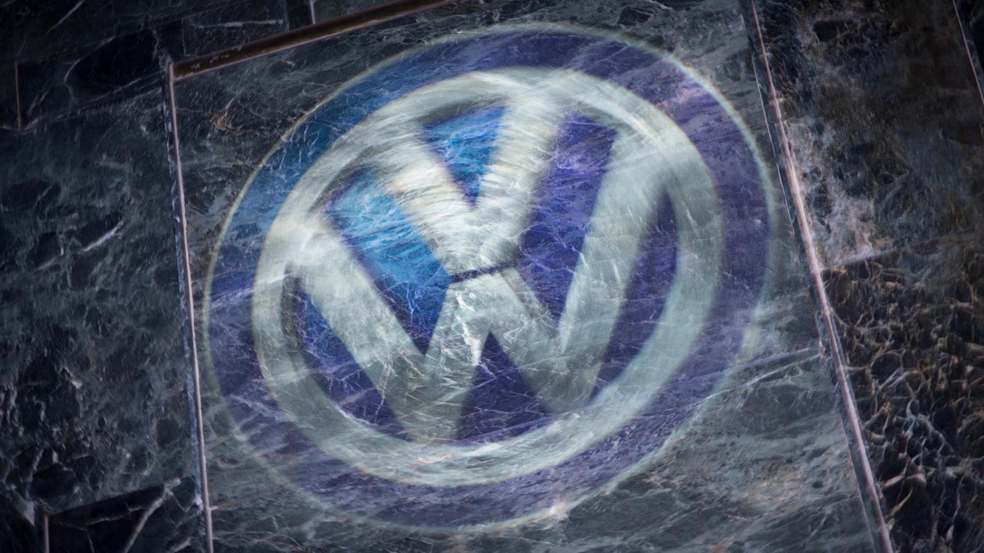 Das Logo von VW mit einer zerkratzten Glasplatte darüber. Das Logo von VW mit einer zerkratzten Glasplatte darüber.