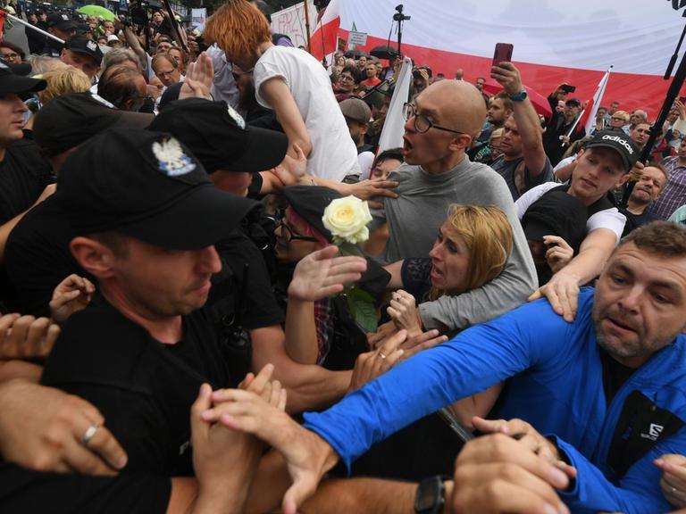 Proteste in Warschau. Polizisten stehen einer aufgebrachten Menschenmenge gegenüber.