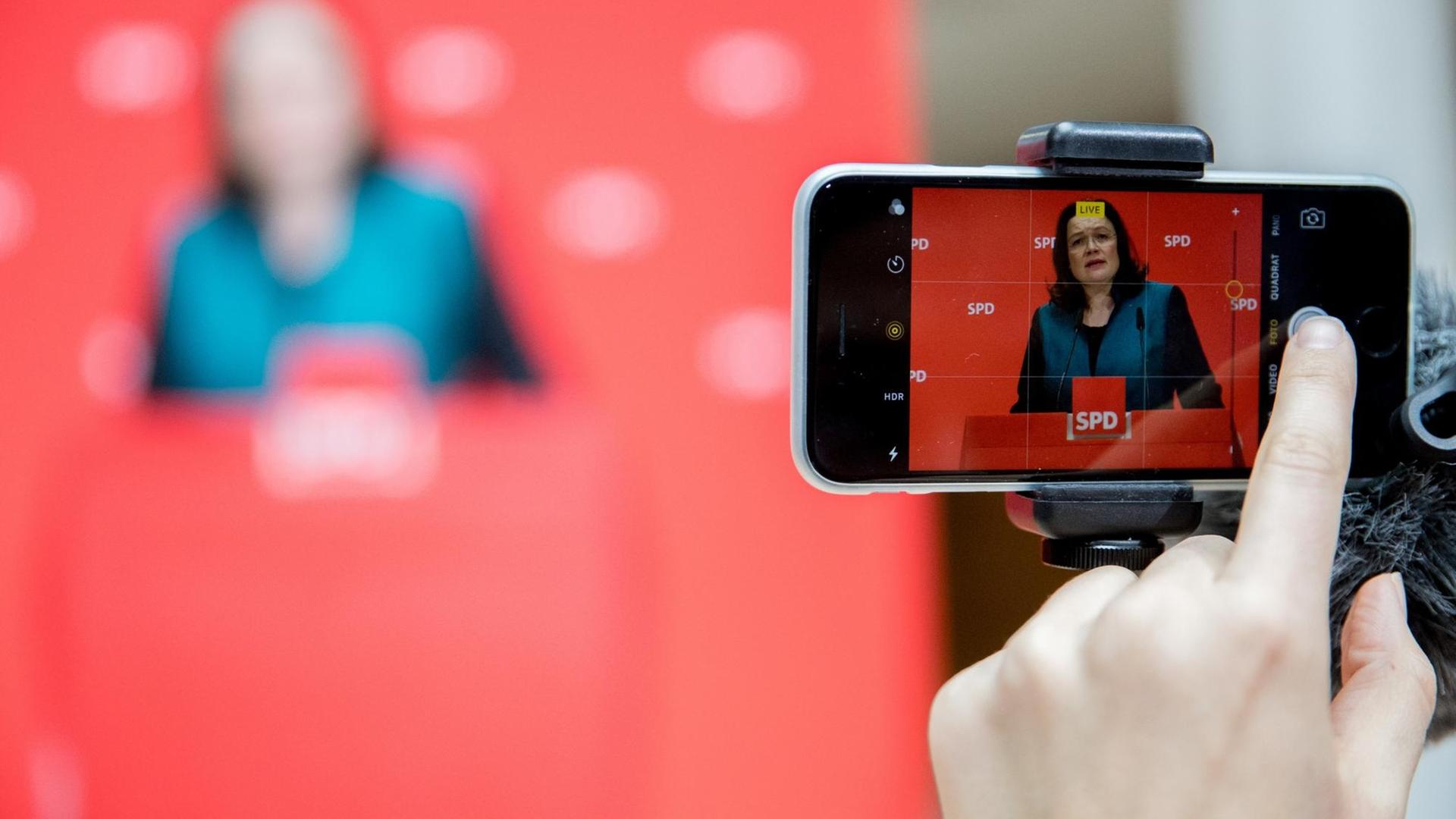 Bundesarbeitsministerin Andrea Nahles (SPD) ist auf einem Smartphone-Display zu sehen.