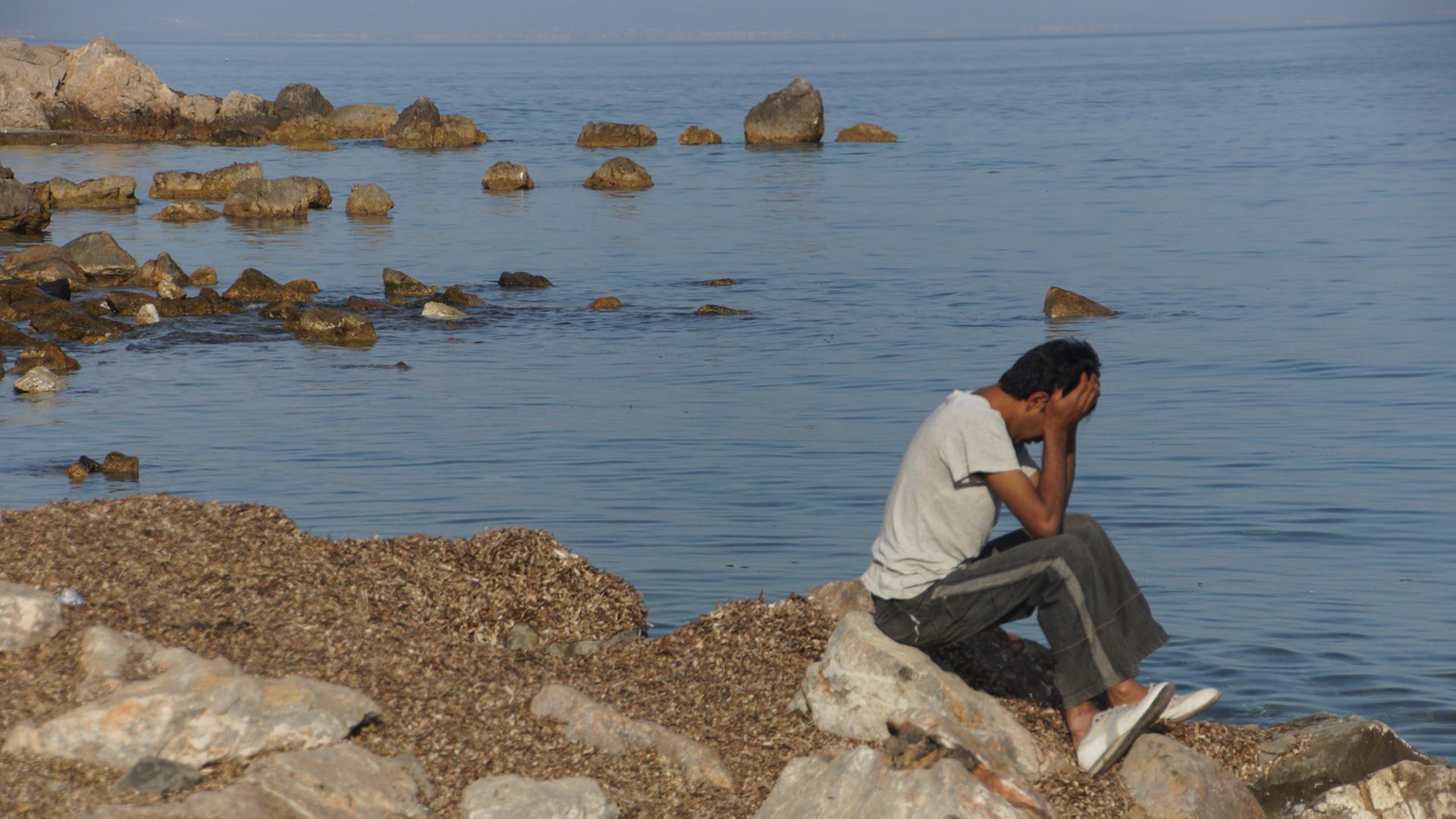 Ein verzweifelter Flüchtling am Strand von Lesbos. Ein verzweifelter Flüchtling am Strand von Lesbos.
