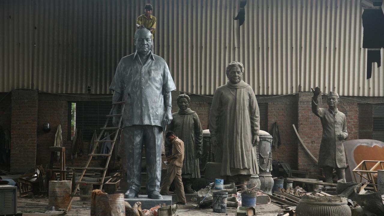 Zu sehen ist eine Bildhauerwerkstatt mit überlebensgroßen Statuen.