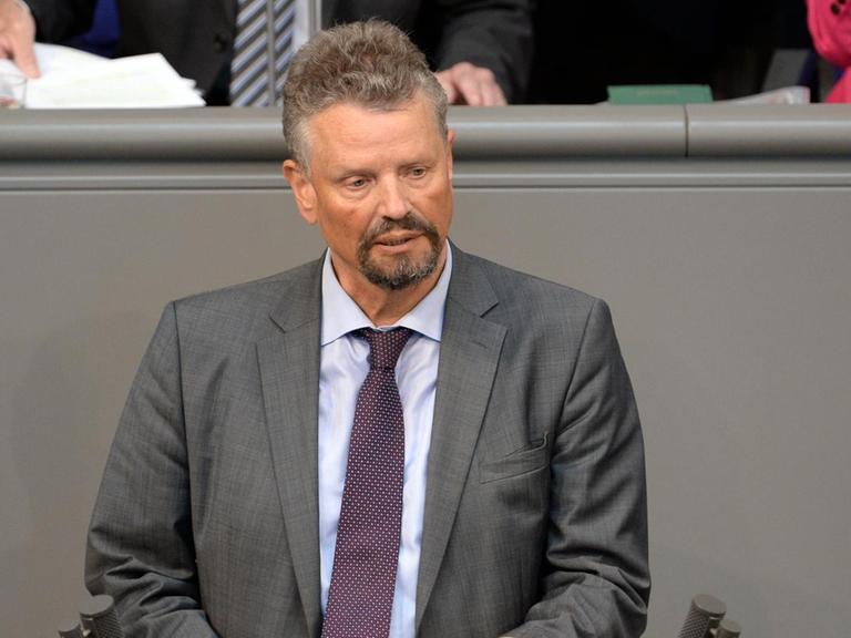 Gernot Erler spricht im grauen Anzug am Rednerpult des Deutschen Bundestages. Er hält sein Manuskript in der Hand.
