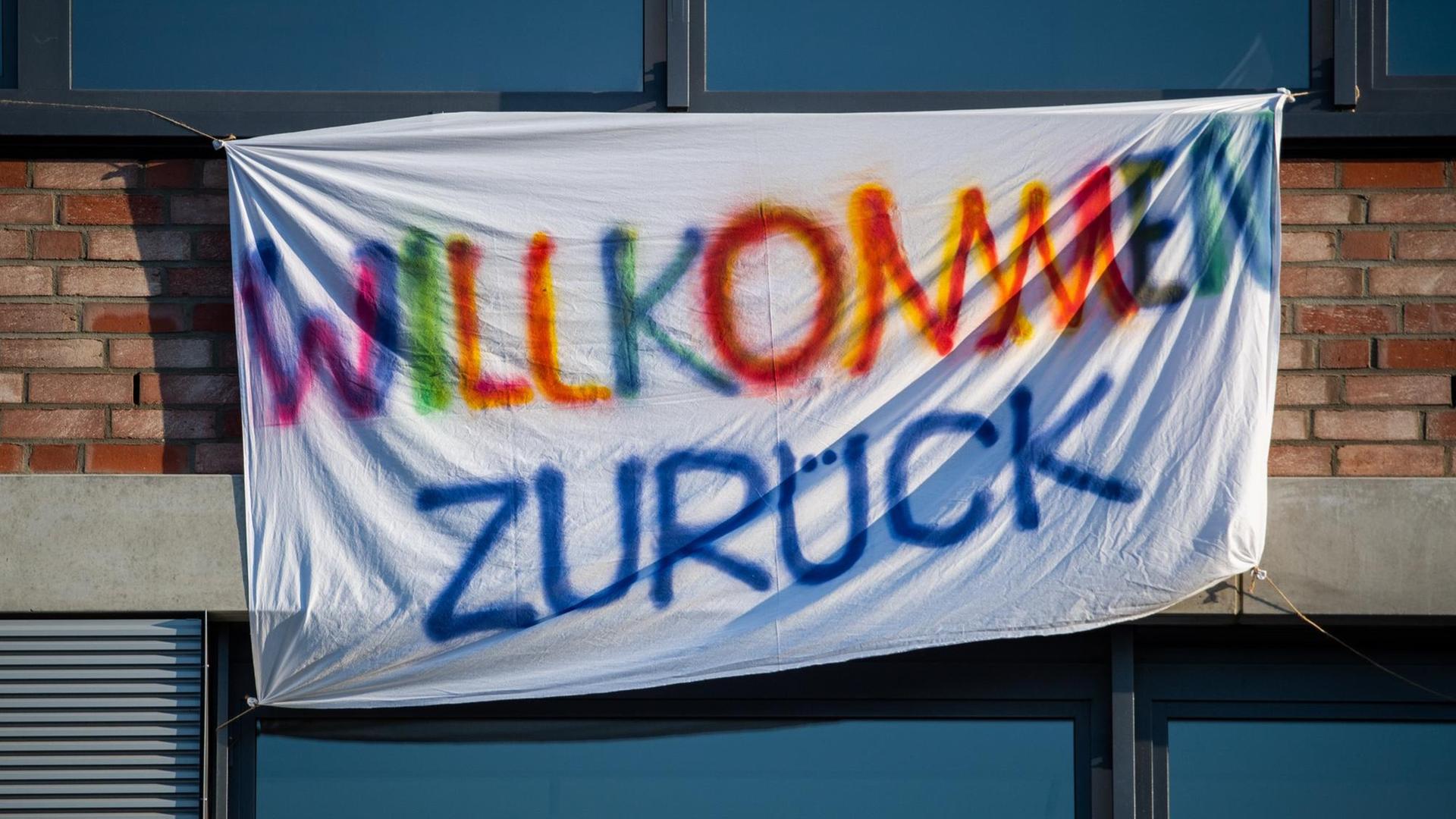 Ein Bettlaken mit der Aufschrift "Willkommen zurück" hängt an einer Schule Ein Bettlaken mit der Aufschrift "Willkommen zurück" hängt an einer Schule