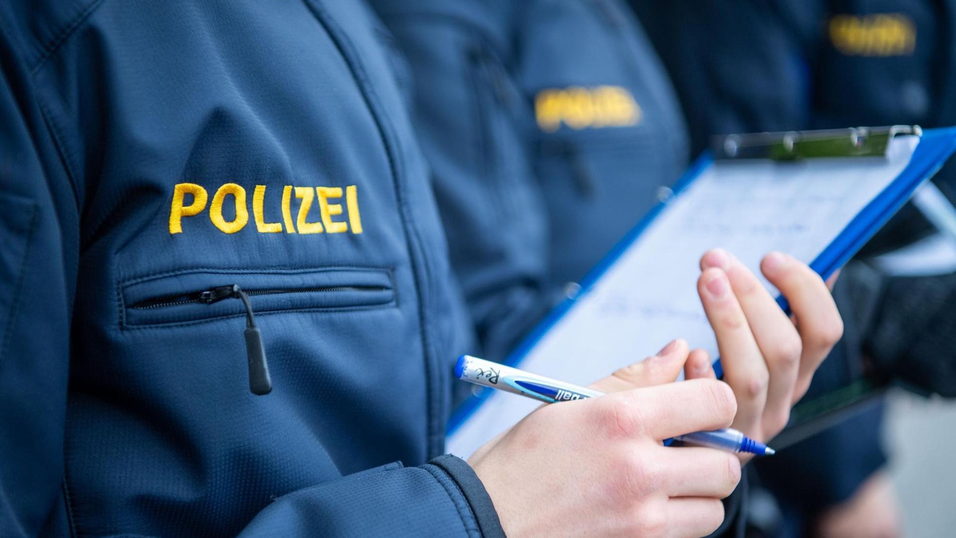 Angehende Streifenpolizisten notieren sich in einer Polizeischule etwas auf einem Notizmäppchen. Angehende Streifenpolizisten notieren sich in einer Polizeischule etwas auf einem Notizmäppchen.