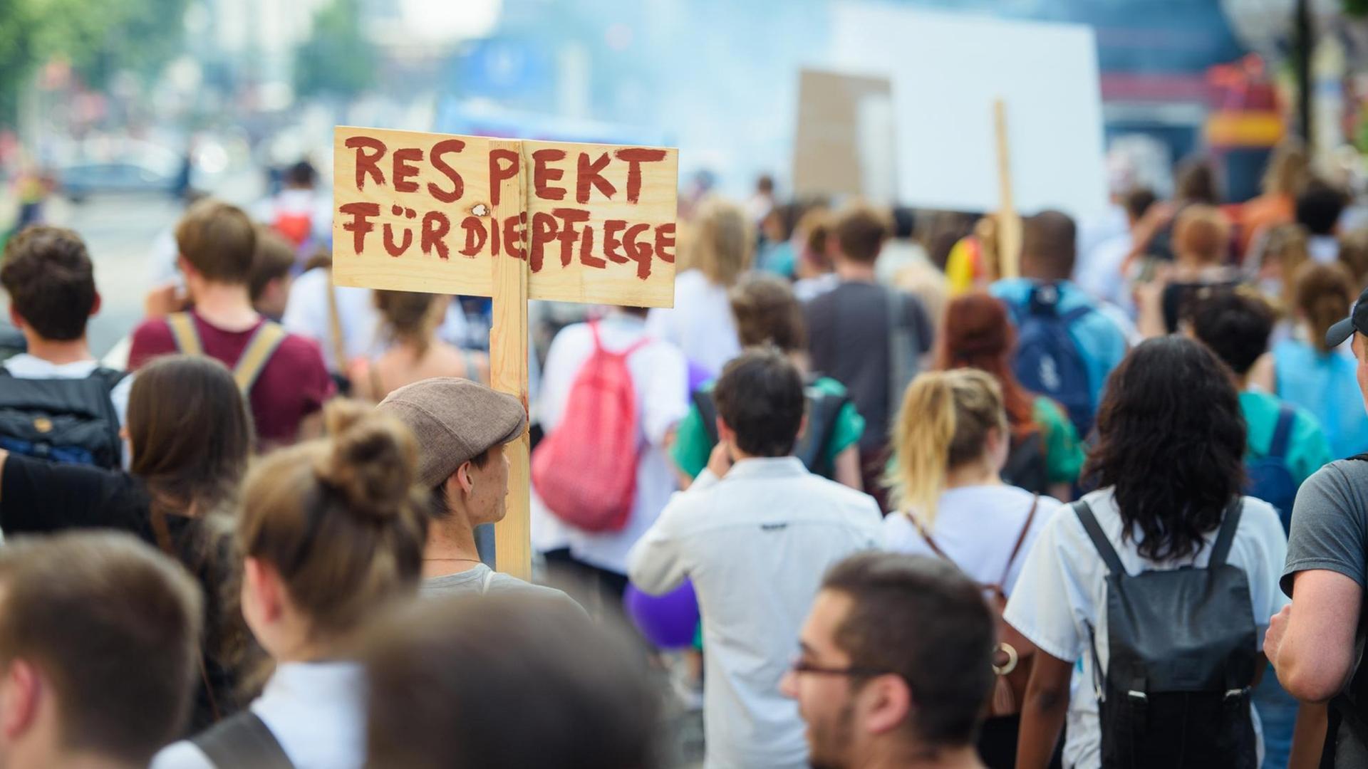 Ein Teilnehmer hält auf einer Demonstration für bessere Arbeitsbedingungen in der Pflegebranche ein Schild mit der Aufschrift "Respekt für die Pflege" anlässlich des Bundesweiten Aktionstages "Tag der Pflege". Ein Teilnehmer hält auf einer Demonstration für bessere Arbeitsbedingungen in der Pflegebranche ein Schild mit der Aufschrift "Respekt für die Pflege" anlässlich des Bundesweiten Aktionstages "Tag der Pflege".
