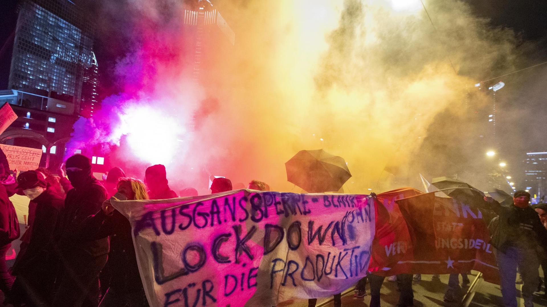 Demonstranten in Frankfurt am Main nehmen an einer Kundgebung gegen die Ausgangsbeschränkungen teil und entzünden dabei Pyrotechnik.
