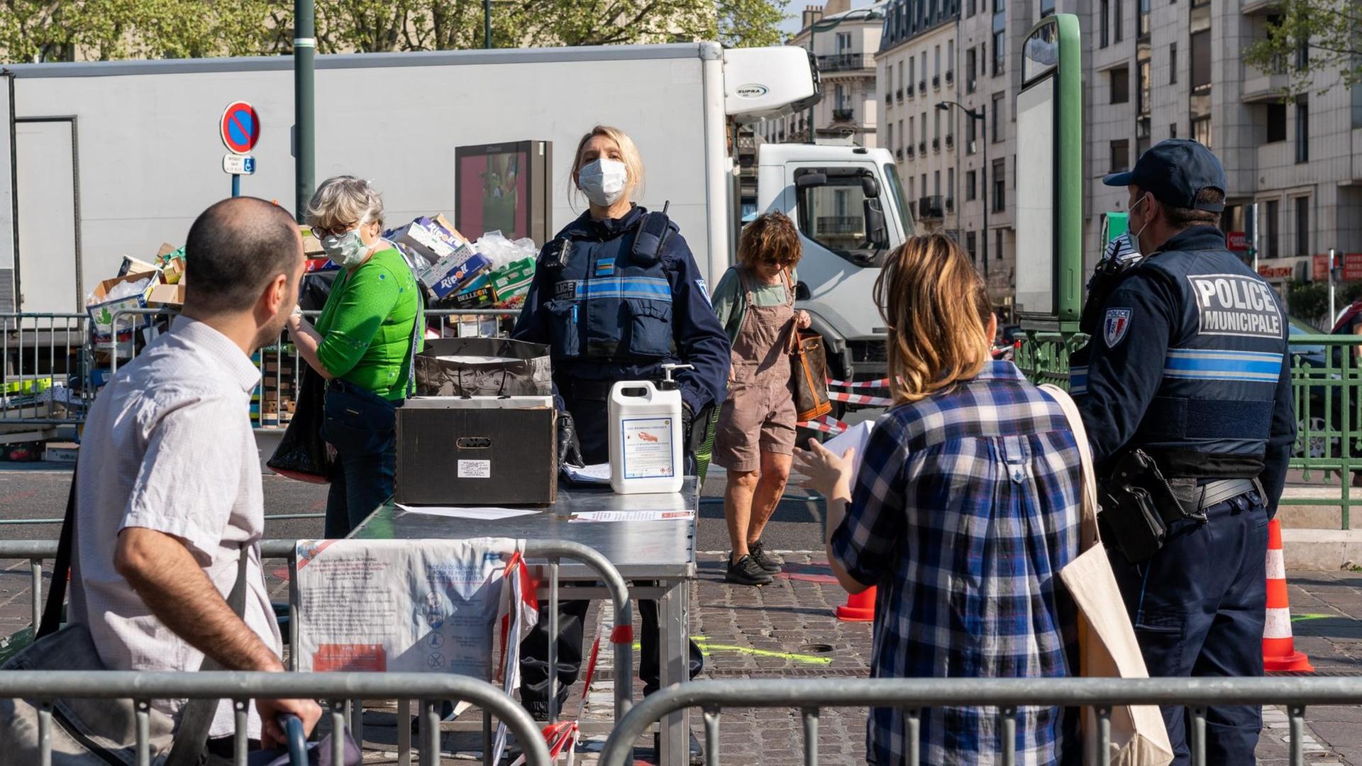 Die Polizei kontrolliert, dass sich die Menschen am Eingang zum Markt von Saint-Mande die Hände desinfizieren. via ZUMA Wire |