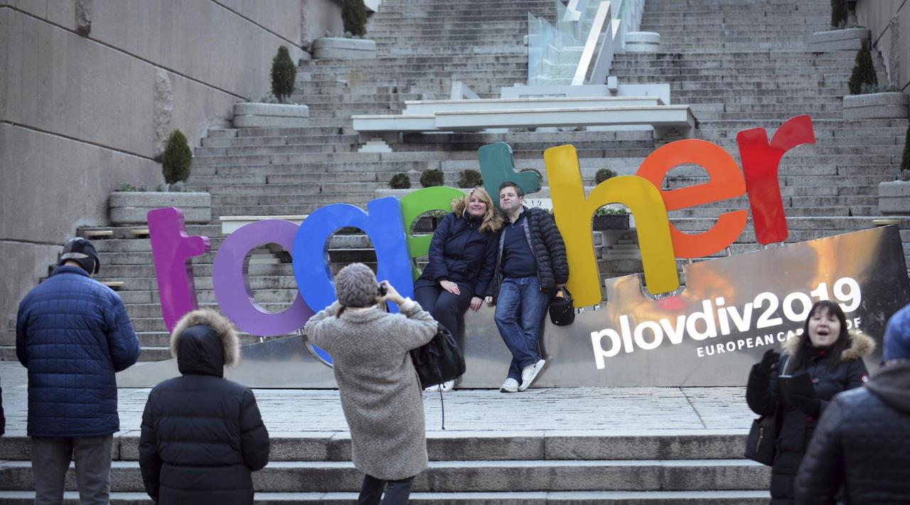 Zwei Menschen lassen sich vor einem bunten Schild mit der Aufschrift "together" fotografieren, mit der die bulgarische Stadt Plowdiw für ihren Titel als europäische Kulturhauptstadt 2019 wirbt.
Zwei Menschen lassen sich vor einem bunten Schild mit der Aufschrift "together" fotografieren, mit der die bulgarische Stadt Plowdiw für ihren Titel als europäische Kulturhauptstadt 2019 wirbt.