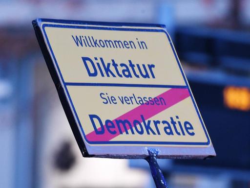 Schild mit der Aufschrift "Willkommen in der Diktatur - Sie verlassen Demokratie" bei der Querdenken-Demonstration in Leipzig am 7.11.2020