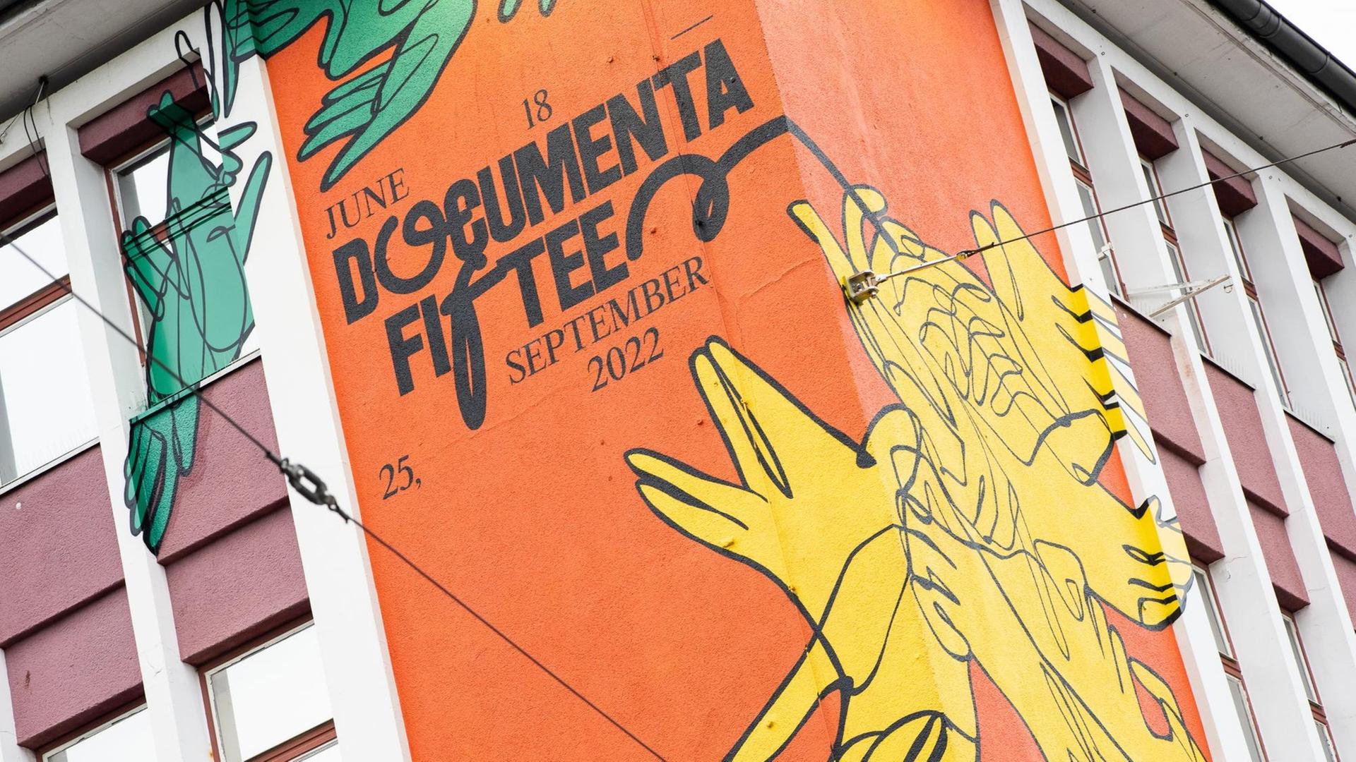 Ein Wandbild mit dem neuen Logo der documenta fifteen ist am sogenannten "ruruHaus" vom indonesischen Kuratorenkollektiv Ruangrupa an einem ehemaligen Sportgeschäft in der Kasseler Innenstadt zu sehen. Ein Wandbild mit dem neuen Logo der documenta fifteen ist am sogenannten "ruruHaus" vom indonesischen Kuratorenkollektiv Ruangrupa an einem ehemaligen Sportgeschäft in der Kasseler Innenstadt zu sehen.