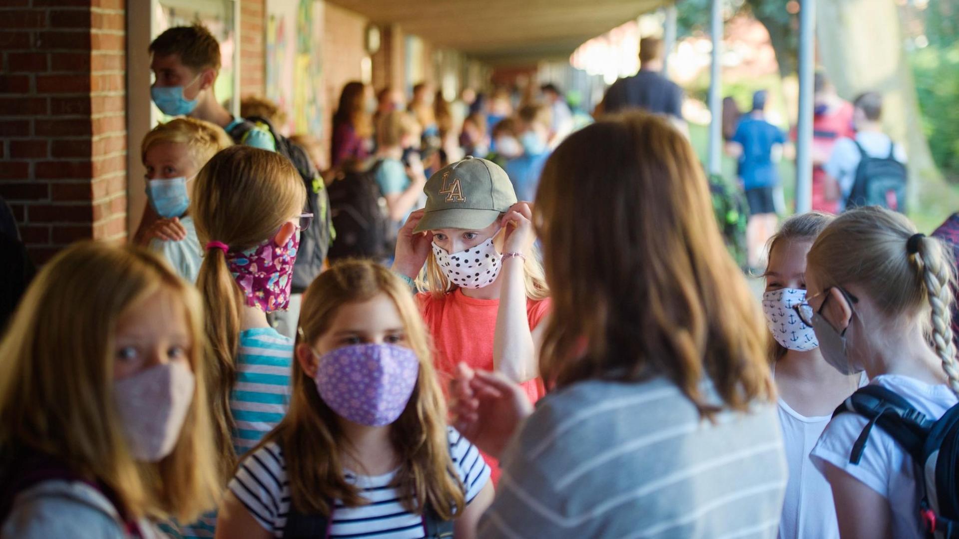 Schülerinnen einer sechsten Klasse stehen vor Beginn des Unterrichts am ersten Schultag nach den Sommerferien an der Max-Planck-Schule in Kiel zusammen. Schülerinnen einer sechsten Klasse stehen vor Beginn des Unterrichts am ersten Schultag nach den Sommerferien an der Max-Planck-Schule in Kiel zusammen.