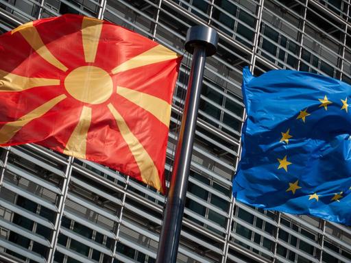 Eine Flagge von Nordmazedonien weht neben einer EU-Flagge im Wind vor dem Berlaymont-Gebäude der EU-Kommission