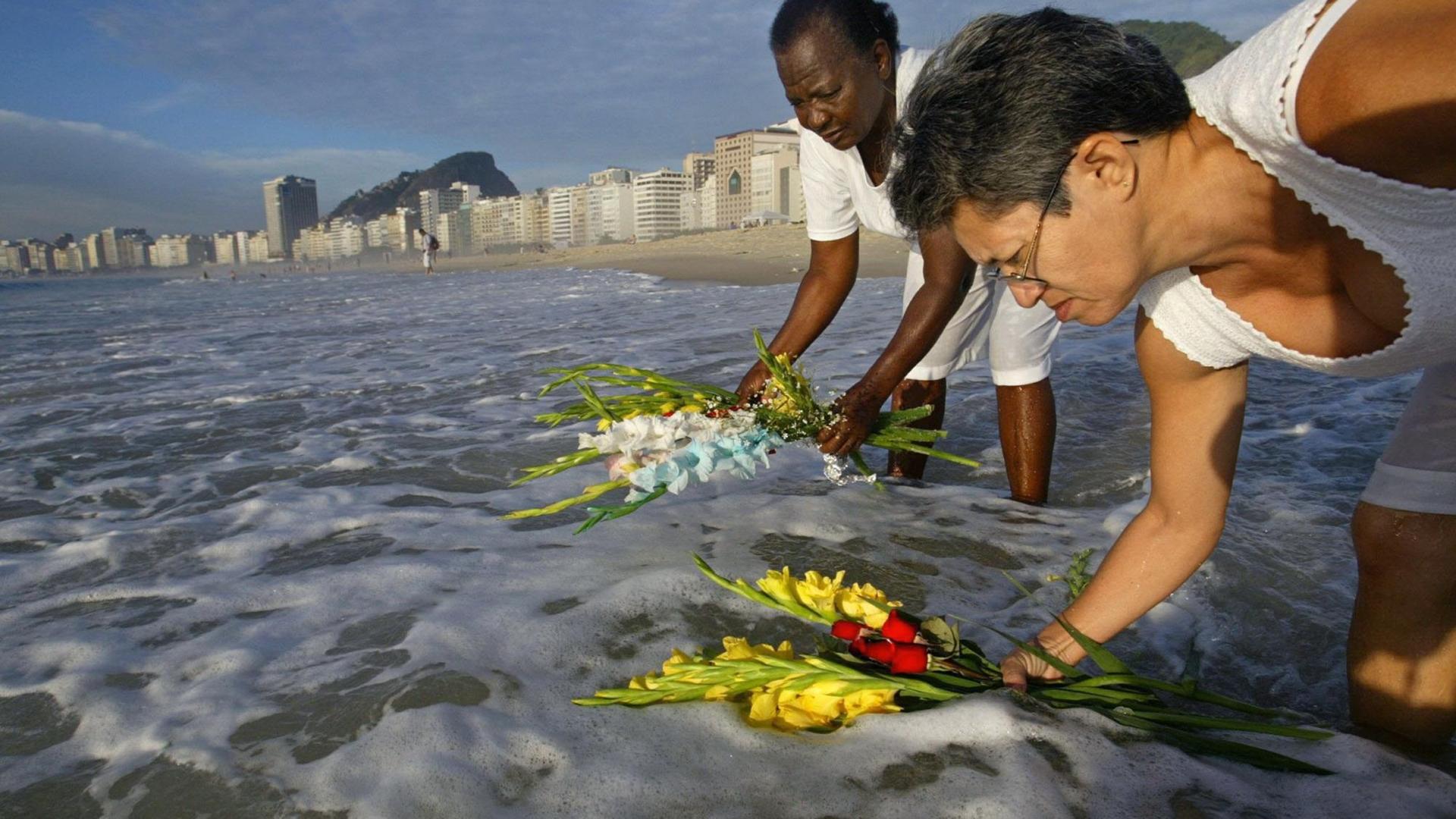 Gläubige opfern Blumen für die Meeresgöttin Iemanjá am Strand von Rio de Janeiro in Brasilien Gläubige opfern Blumen für die Meeresgöttin Iemanjá am Strand von Rio de Janeiro in Brasilien