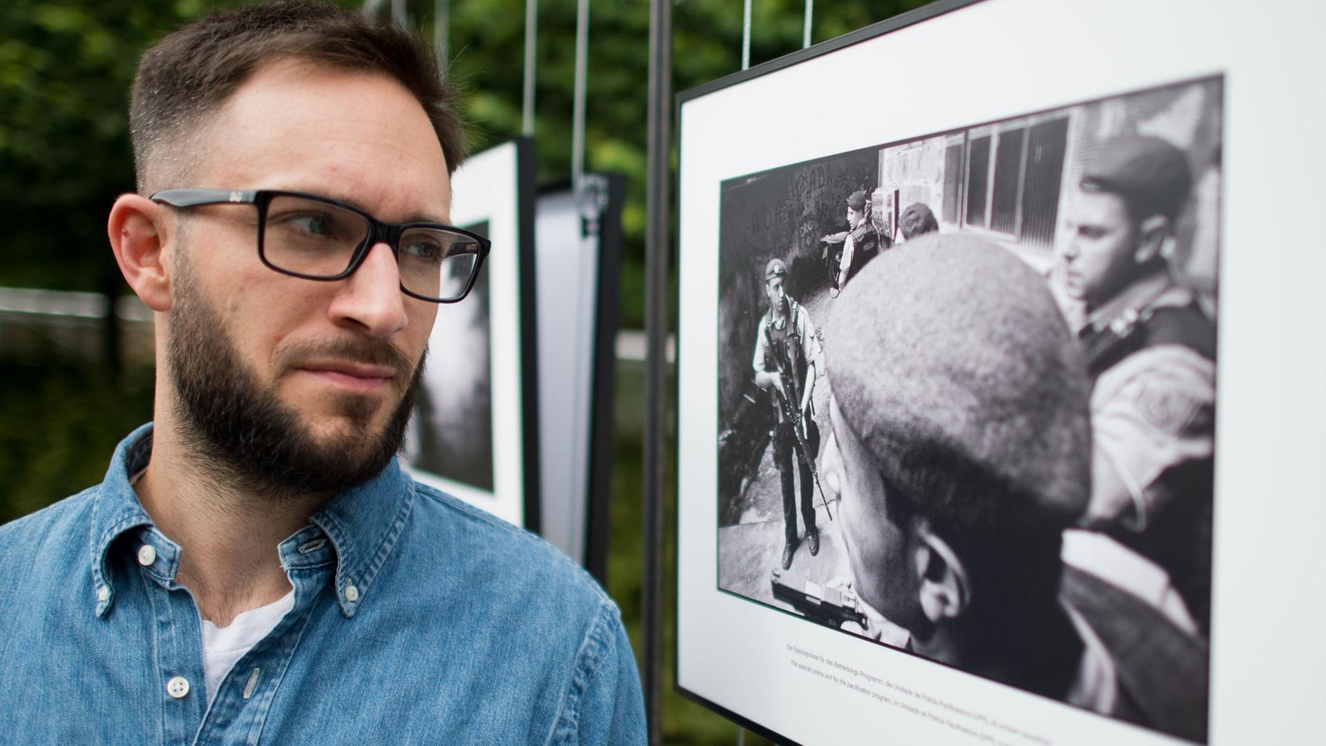 Der Fotograf Felix Kleymann steht am 17.06.2014 beim "4. Lumix Festival für jungen Fotojournalismus" an der Fachhochschule Hannover (Niedersachsen) neben einem Foto aus seiner Serie "Pacificacao", die sich mit einer Favela in Rio de Janeiro auseinandersetzt. Der Fotograf Felix Kleymann steht am 17.06.2014 beim "4. Lumix Festival für jungen Fotojournalismus" an der Fachhochschule Hannover (Niedersachsen) neben einem Foto aus seiner Serie "Pacificacao", die sich mit einer Favela in Rio de Janeiro auseinandersetzt.