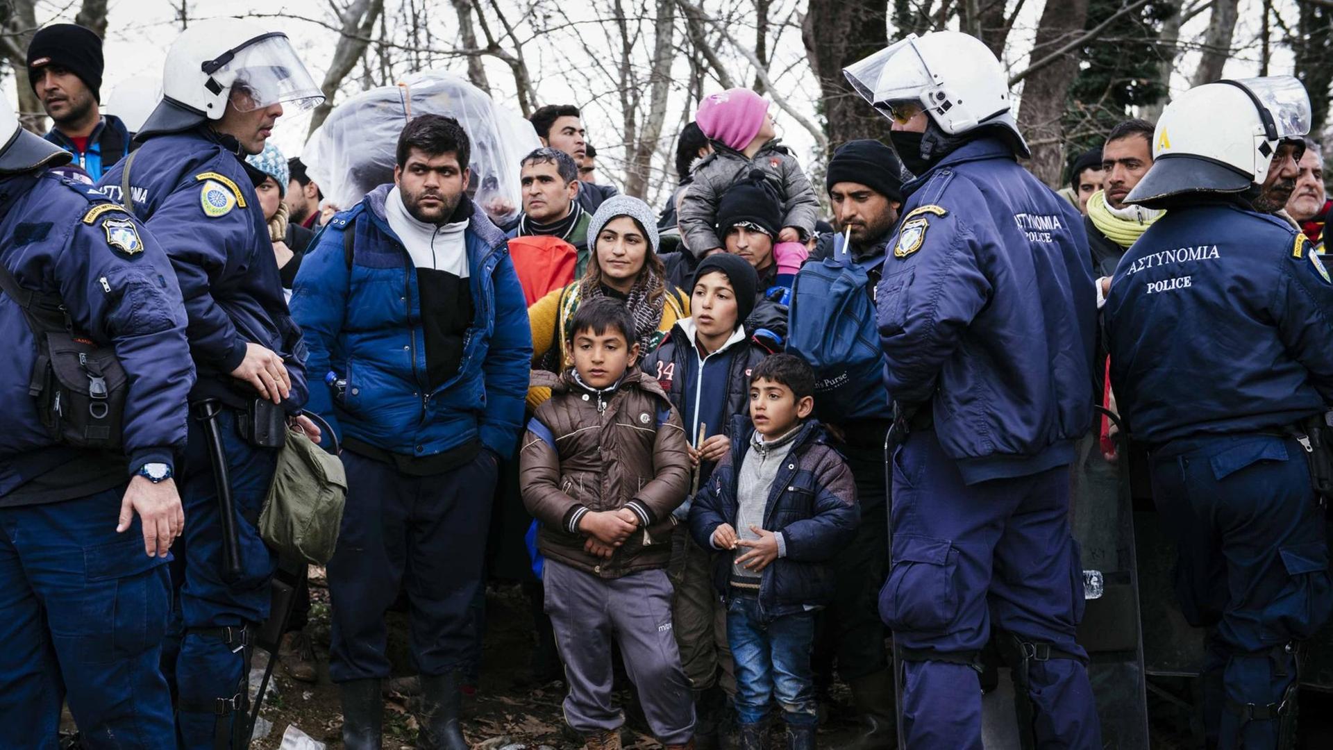 Polizisten umringen Flüchtlinge Polizisten umringen Flüchtlinge