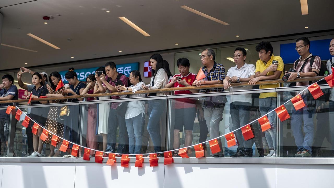 Pro-Peking Protestanten hinter chinesischen Flaggen in einer Mall in Hongkong. Zuvor hatte sich die Demokratiebewegung in Shopping-Centern zu spontanen Gesangseinlagen getroffen.
Pro-Peking Protestanten hinter chinesischen Flaggen in einer Mall in Hongkong. Zuvor hatte sich die Demokratiebewegung in Shopping-Centern zu spontanen Gesangseinlagen getroffen.
