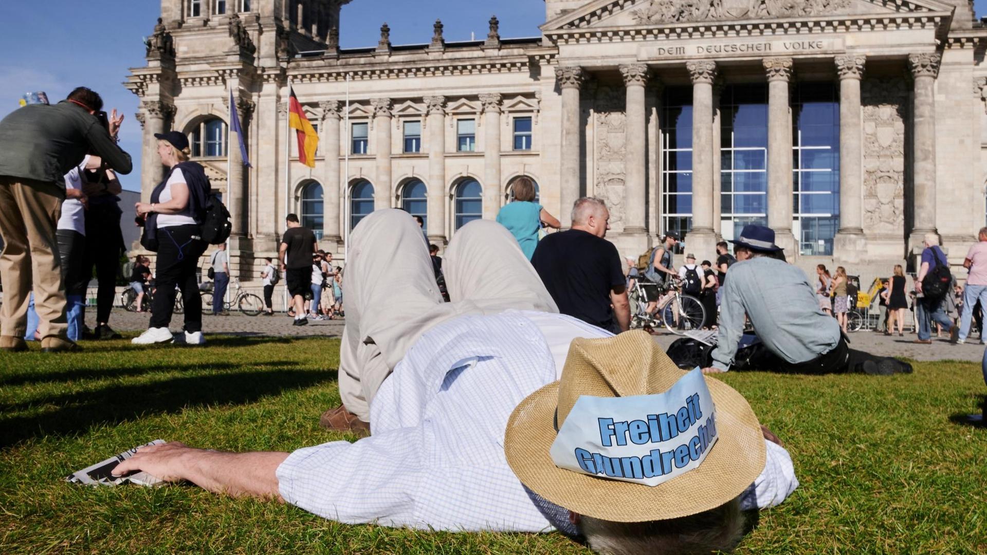 "Freiheit – Grundrechte" steht auf einem Hut, den ein Demonstrant auf der Wiese liegend trägt. Vor dem Reichstag fand die Kundgebung "Demokratischer Widerstand, für die Wiederherstellung verfassungsgemäßer Demokratie" statt. "Freiheit – Grundrechte" steht auf einem Hut, den ein Demonstrant auf der Wiese liegend trägt. Vor dem Reichstag fand die Kundgebung "Demokratischer Widerstand, für die Wiederherstellung verfassungsgemäßer Demokratie" statt.