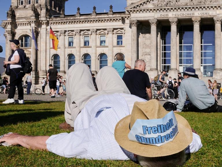 "Freiheit – Grundrechte" steht auf einem Hut, den ein Demonstrant auf der Wiese liegend trägt. Vor dem Reichstag fand die Kundgebung "Demokratischer Widerstand, für die Wiederherstellung verfassungsgemäßer Demokratie" statt.