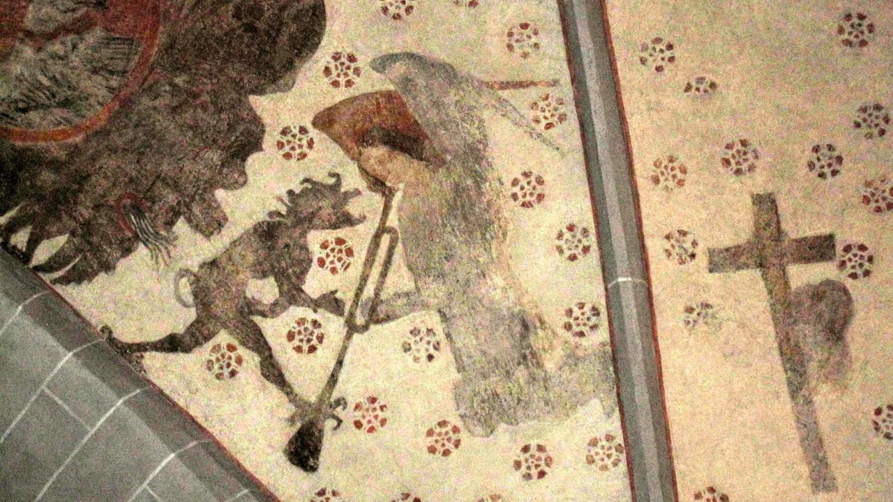 Ein Deckengemälde in der Kirche von Lieberhausen zeigteinen Dämon, der Schabernack mit einem Engel treibt, der eine Trompete hält. Ein Deckengemälde in der Kirche von Lieberhausen zeigteinen Dämon, der Schabernack mit einem Engel treibt, der eine Trompete hält.