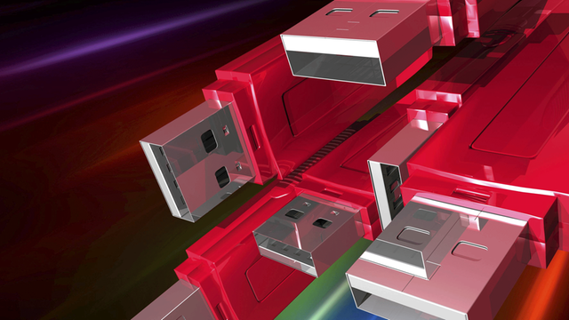Mehrere rote USB-Sticks vor einem bunten Hintergrund.
