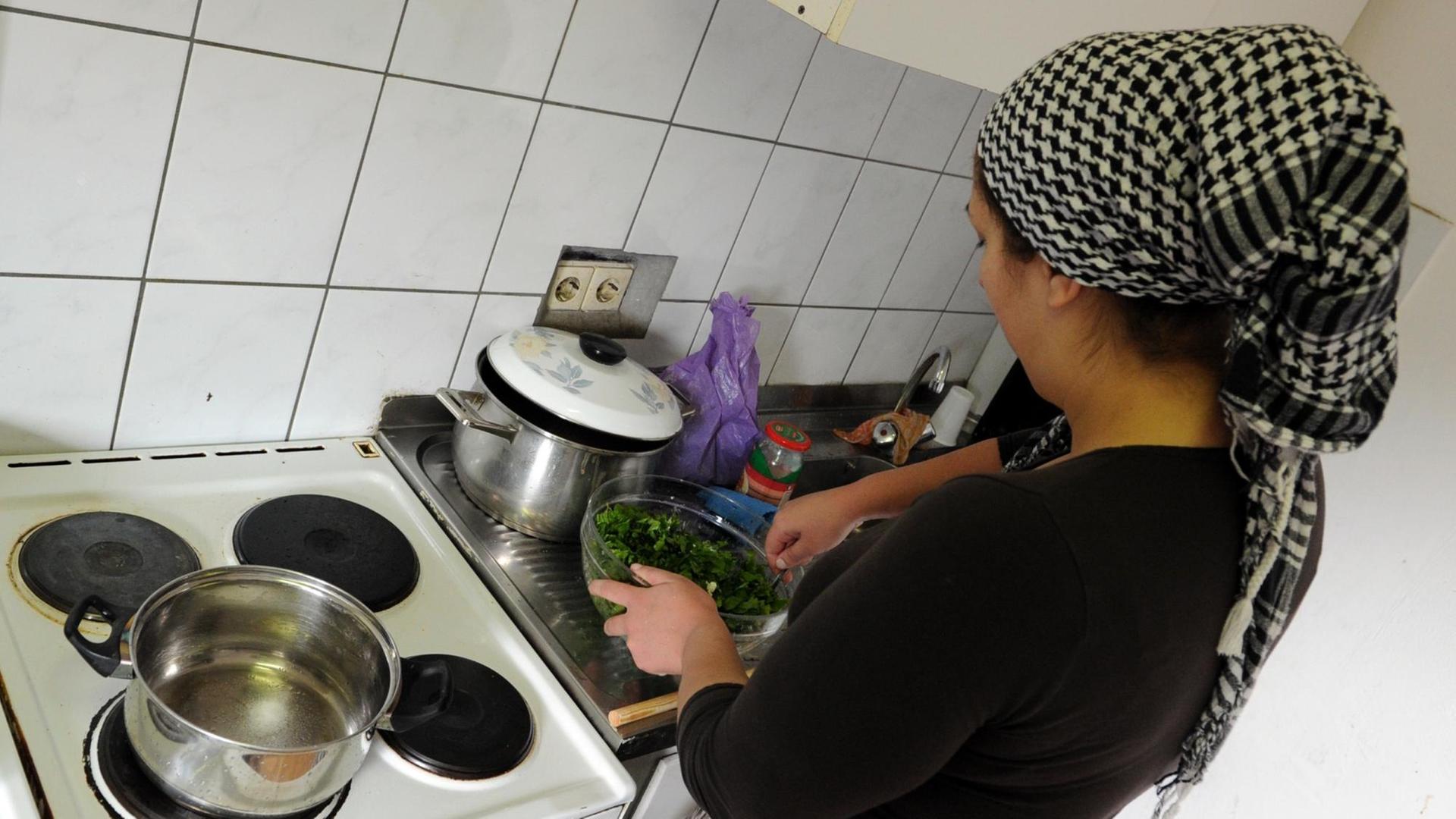 Eine Frau kocht am 04.04.2013 in einer Küche in Tübingen (Baden-Württemberg). Eine Frau kocht am 04.04.2013 in einer Küche in Tübingen (Baden-Württemberg).
